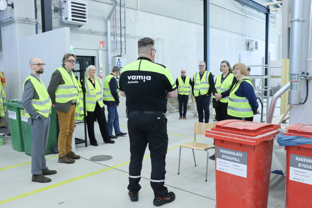 Vamian johtoryhmä ja OKM vieraat ATM-hallissa.