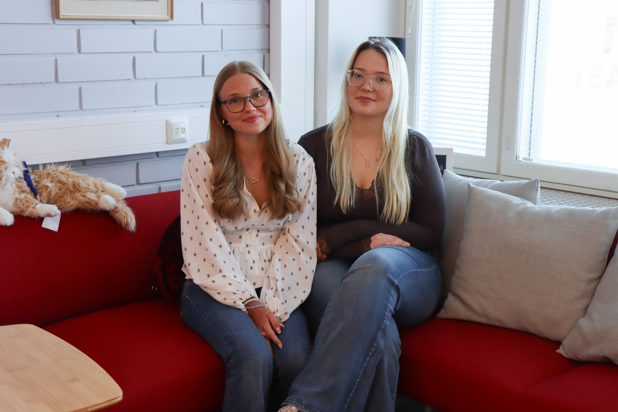 Kaksi tyttöä istuu sohvalla